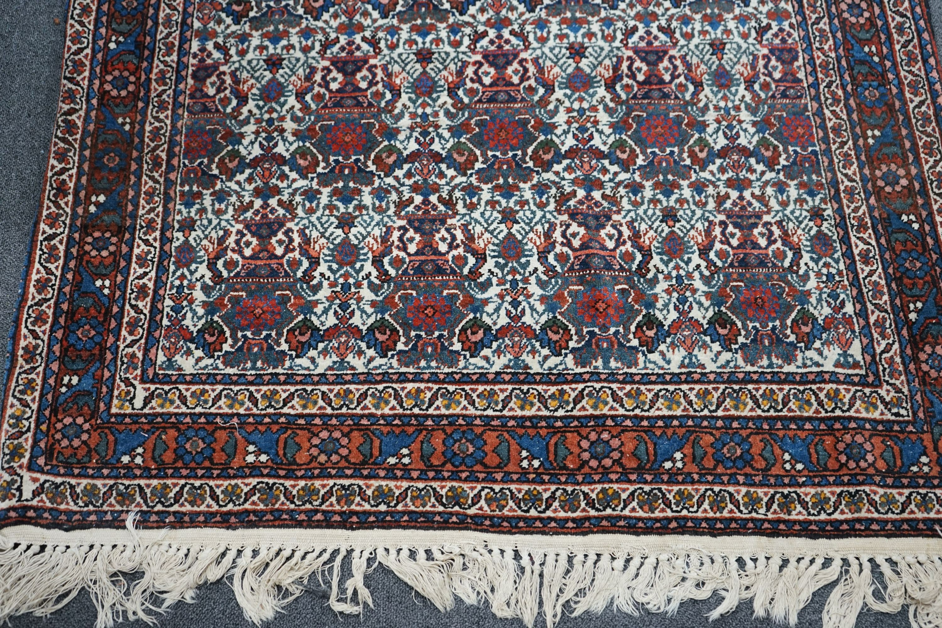 A Persian blue ground rug decorated with Zil-i-Soltan motifs on ivory fields, 106 x 152cm